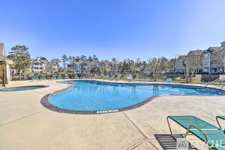 A large outdoor swimming pool with a green bench.