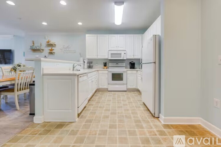 A kitchen with white cabinets and a checkered floor.