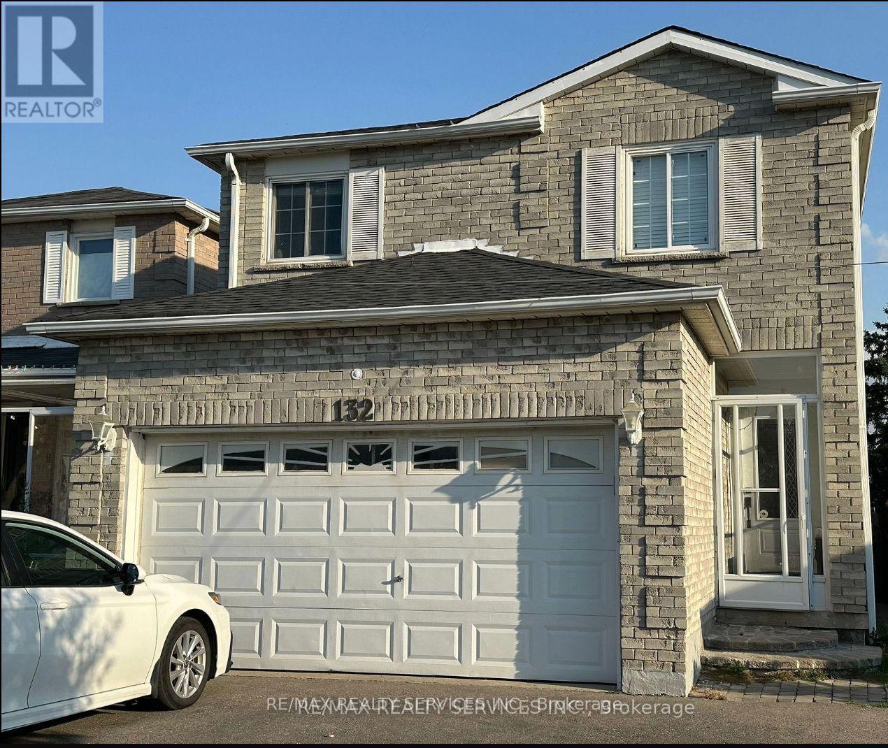 A house with a white car parked in front.