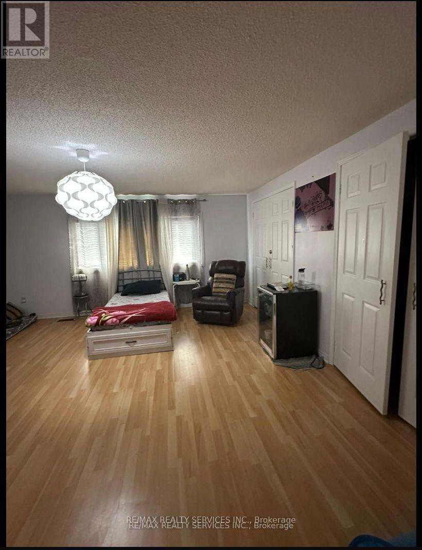 A bedroom with a bed, chair, and a cabinet.