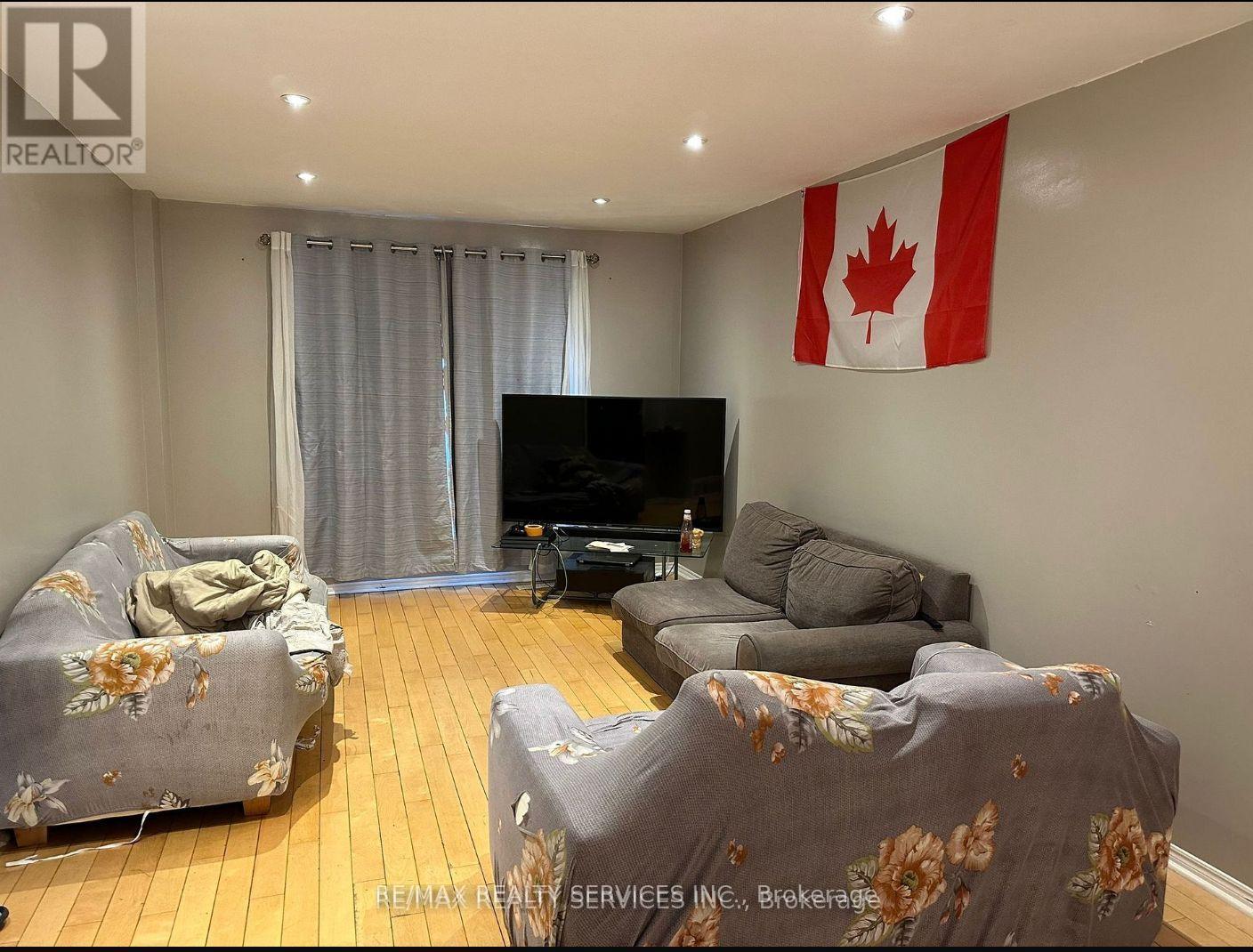 A living room with a grey couch and a TV.