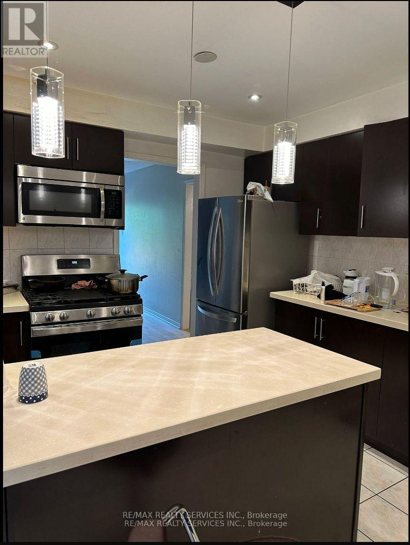 A kitchen with a stove top oven and a refrigerator.