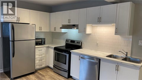 A kitchen with white cabinets and stainless steel appliances.