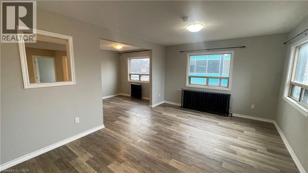 A spacious room with wood flooring and a window.