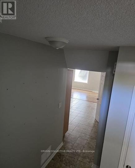 A room with a white ceiling and a doorway leading to another room.