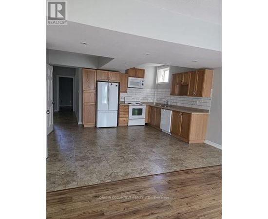 A kitchen with wooden cabinets and a tiled floor.