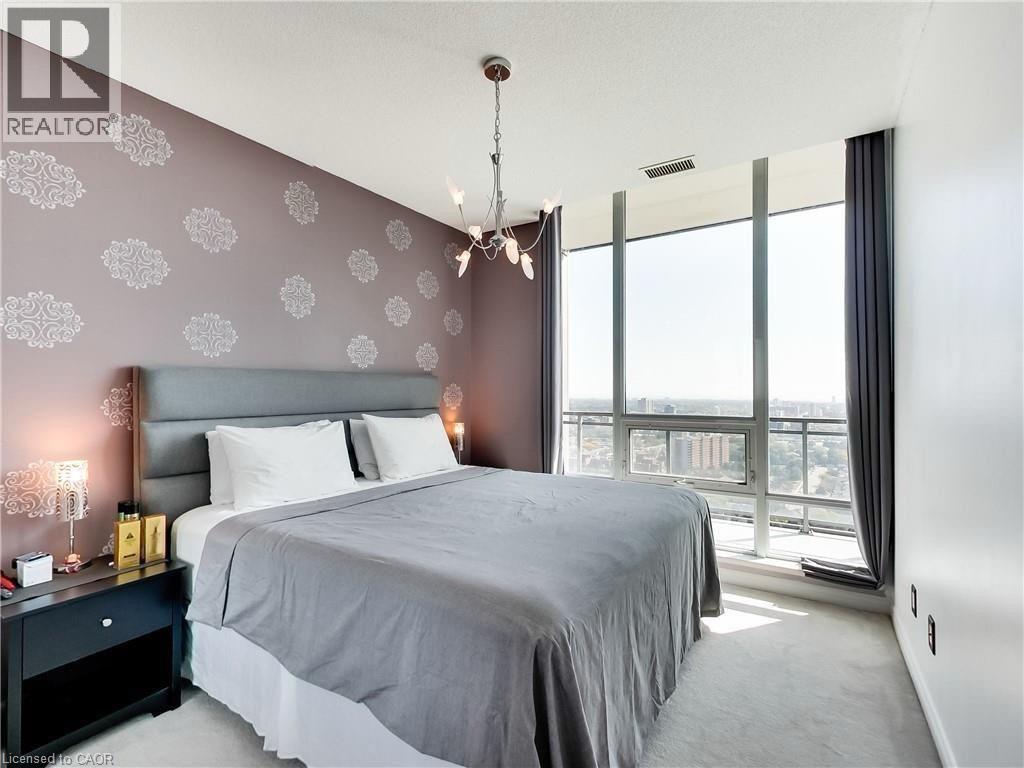 A bedroom with a large bed and a chandelier.