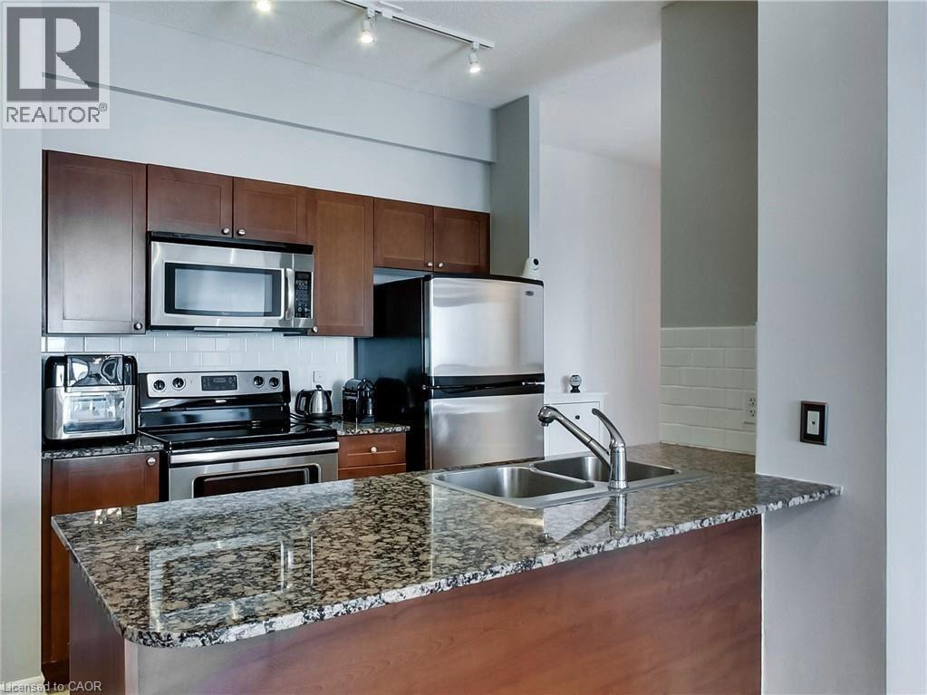 A kitchen with a granite counter top and stainless steel appliances.