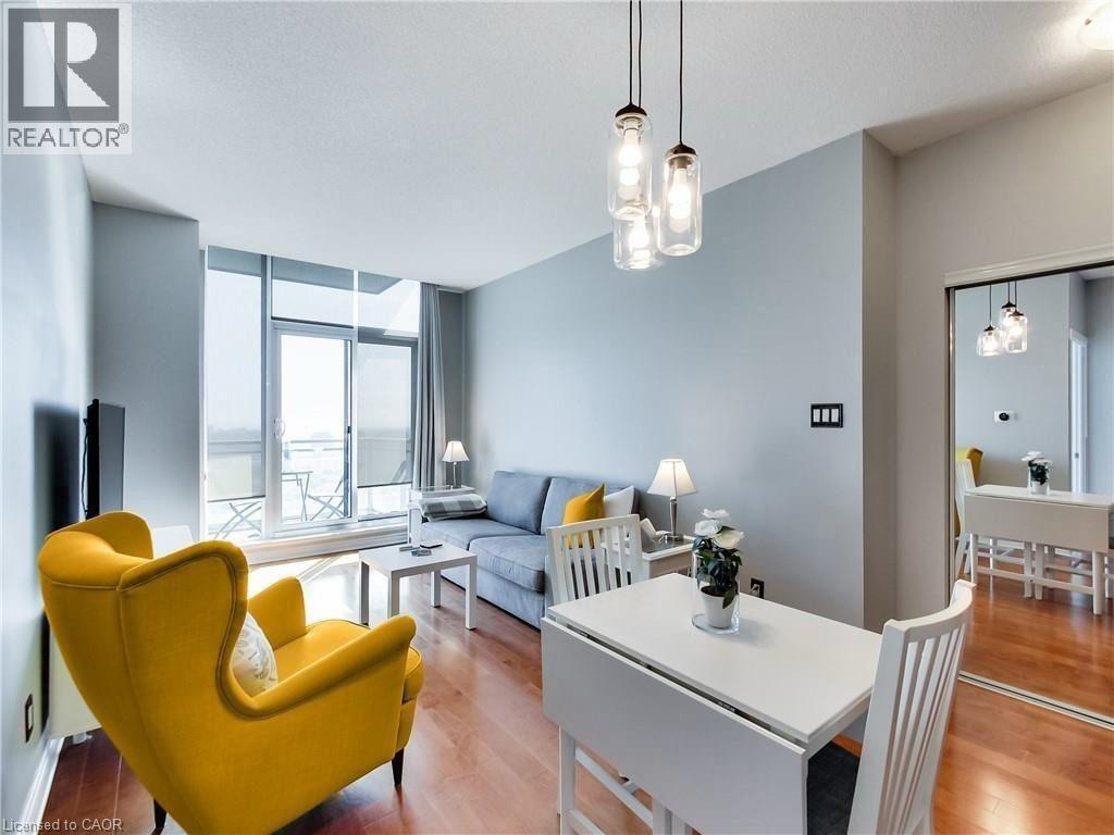 A living room with a yellow chair and a white dining table.