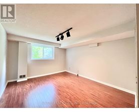 A room with wooden flooring and a window letting in natural light.