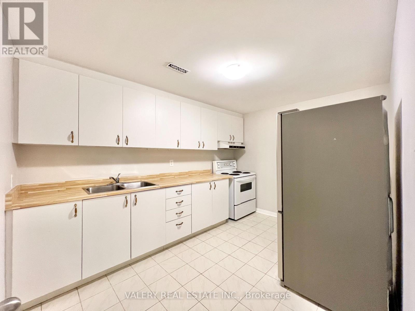A kitchen with white cabinets and a sink.