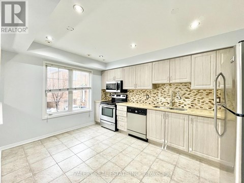 A kitchen with white cabinets and a tile backsplash.