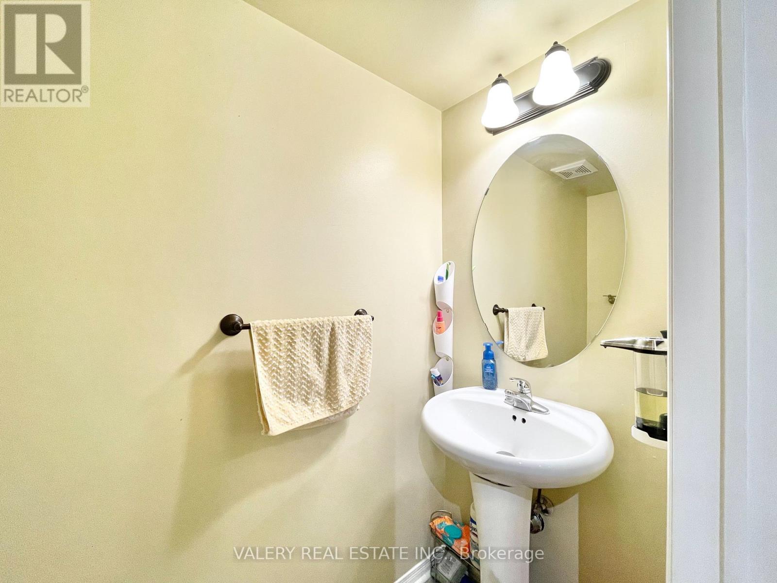 A bathroom with a sink, mirror, and towel.