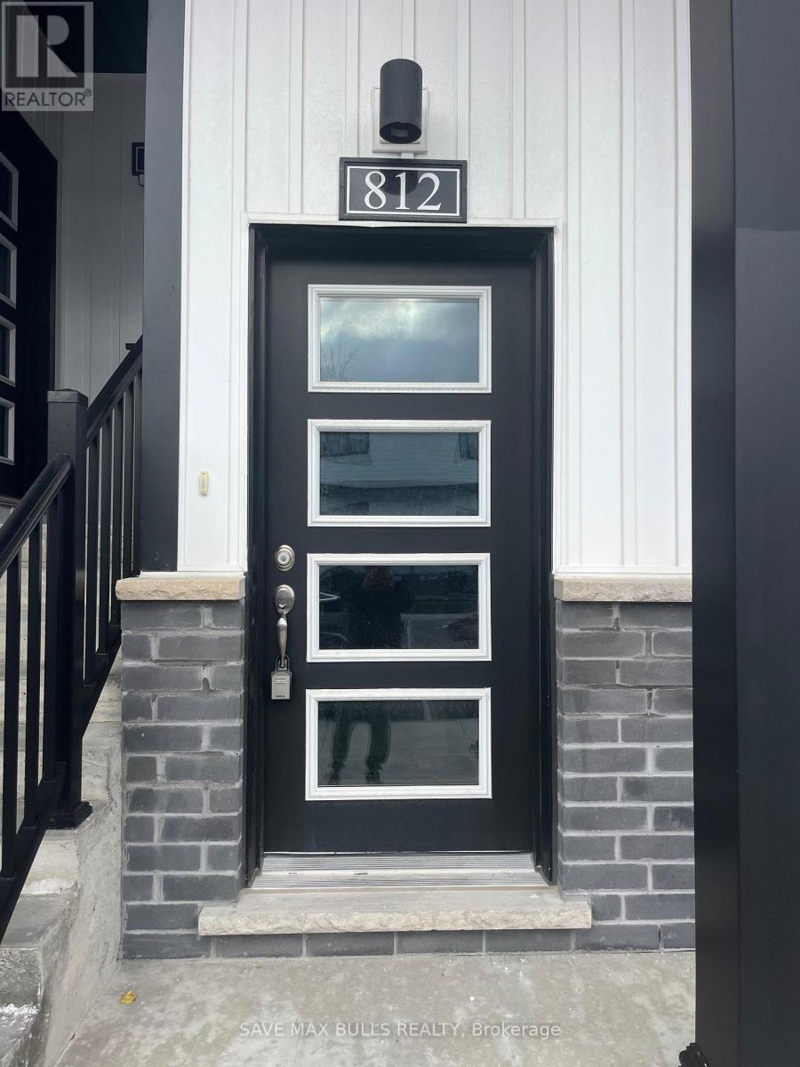 A black door with a glass window is on the front of a building.