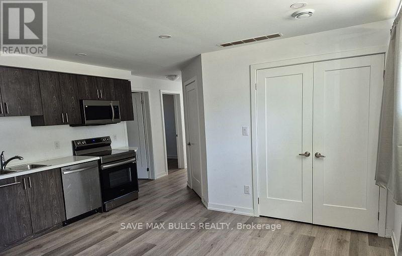 A kitchen with a sink, stove, and cabinets.