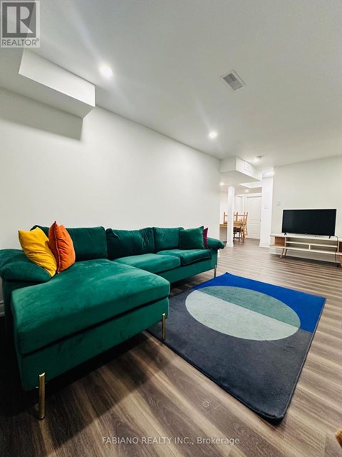 A living room with a green couch and a blue rug.