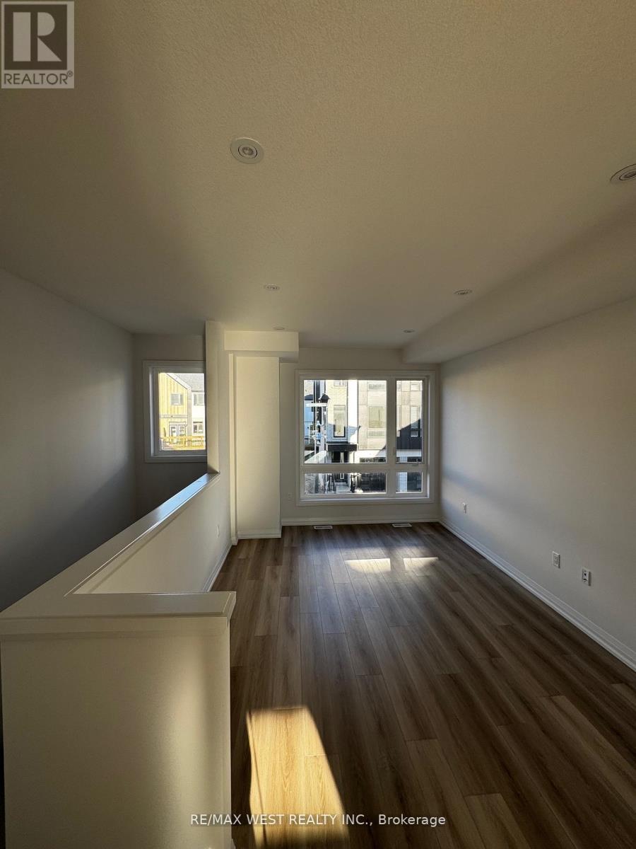 A spacious room with wooden floors and a large window.