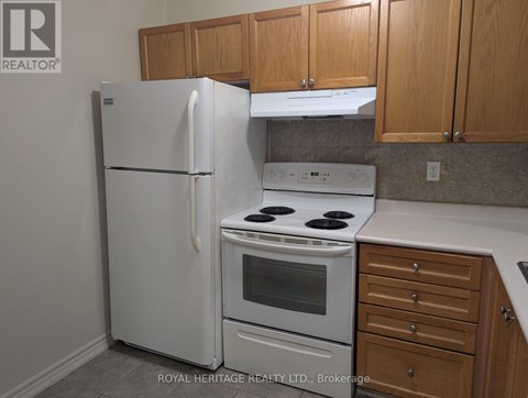 A white refrigerator and oven in a kitchen.