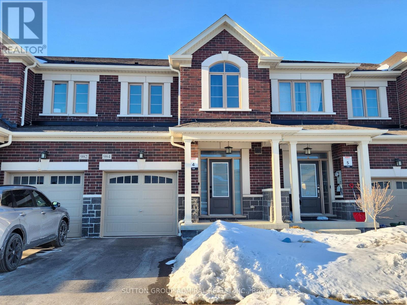 A house with a red brick facade and a white garage door.