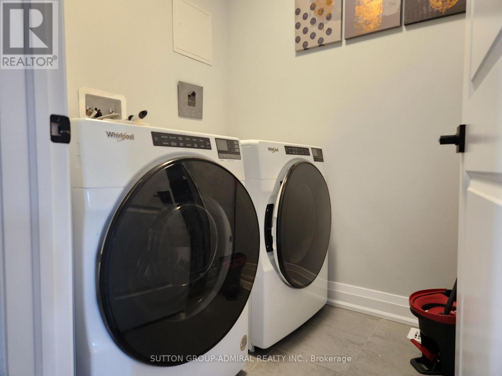 Two Whirlpool washing machines in a laundry room.