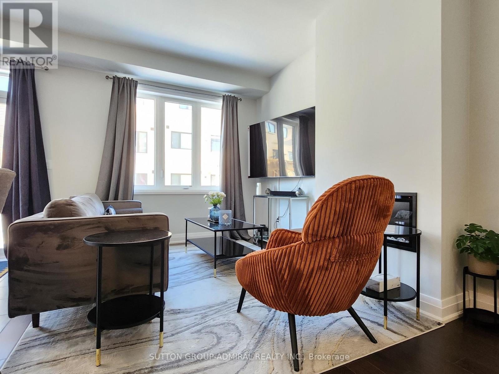 A living room with a brown chair and a grey sofa.