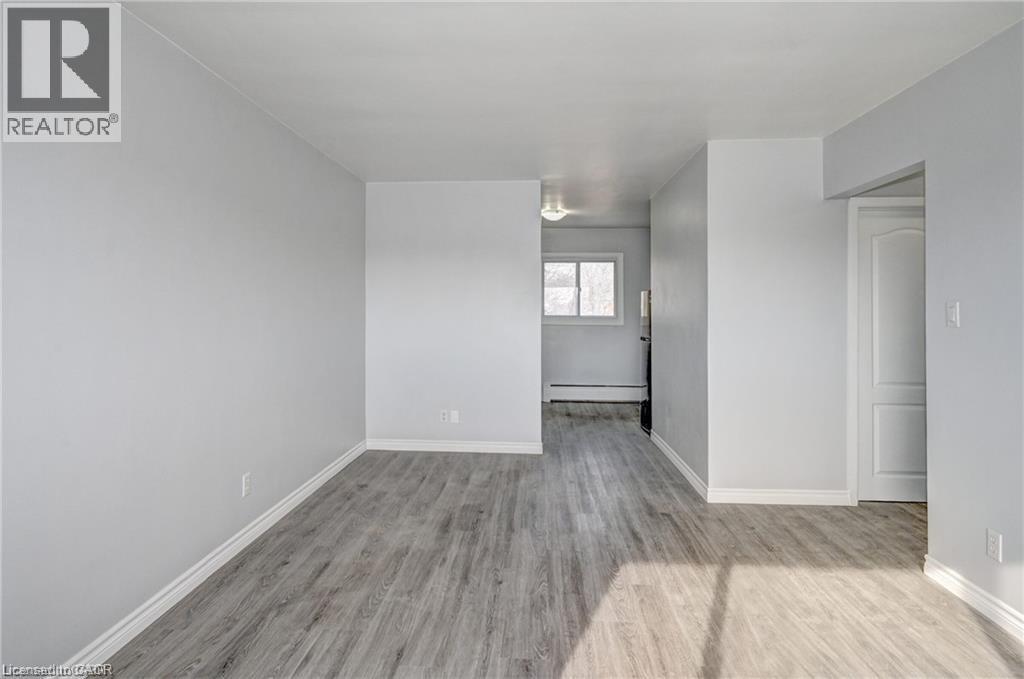 A spacious room with wooden flooring and white walls.