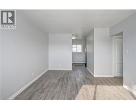 A spacious room with wooden flooring and white walls.