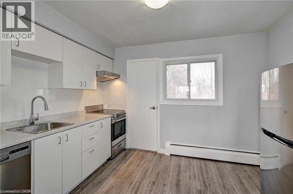 A kitchen with white cabinets and a window.