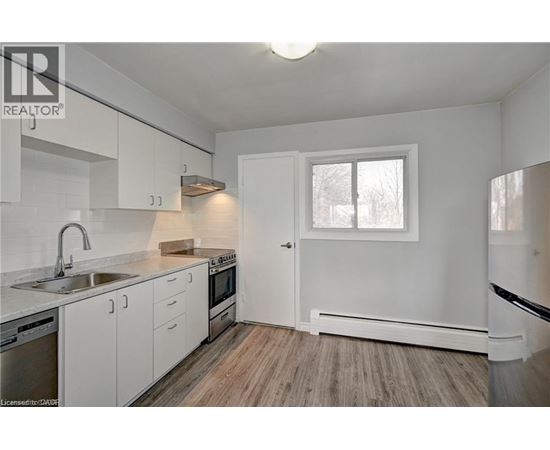A kitchen with white cabinets and a window.