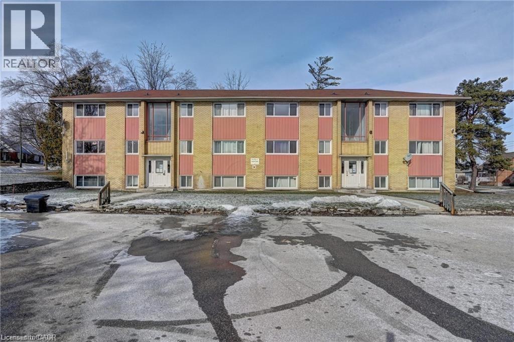 A large, multi-story building with a parking lot in front.