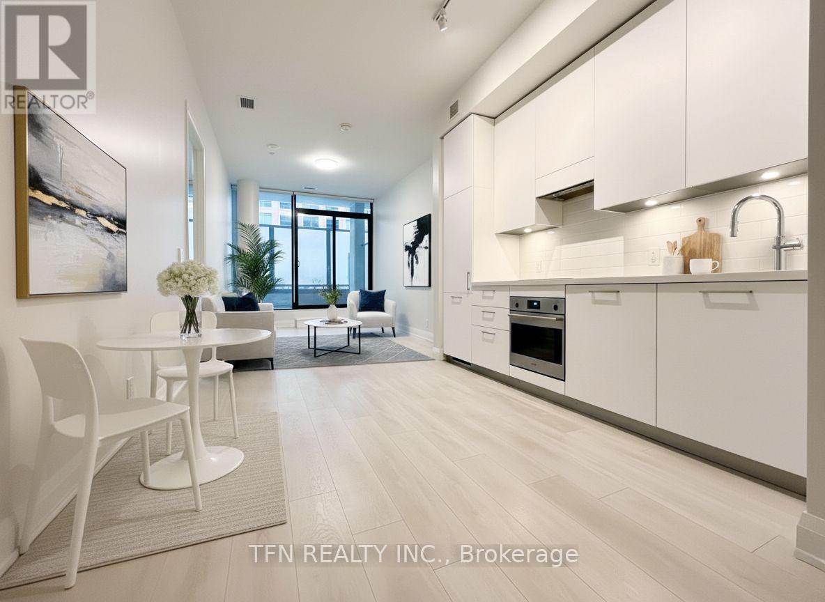 A modern kitchen with white cabinets and a dining table.
