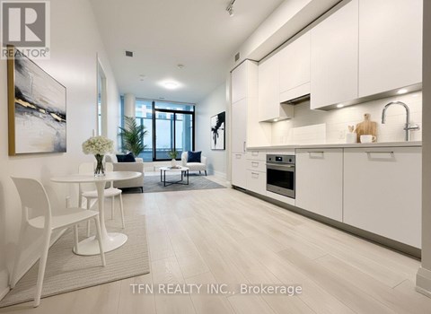 A modern kitchen with white cabinets and a dining table.