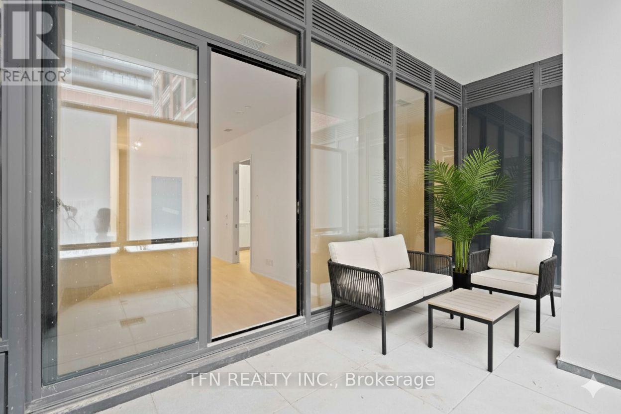 A modern living room with a glass door and a plant.