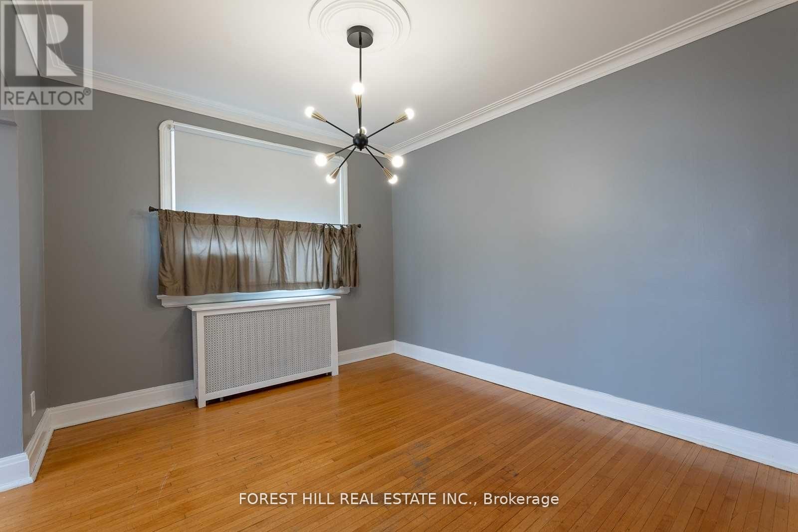 A room with a ceiling fan and a radiator against the wall.