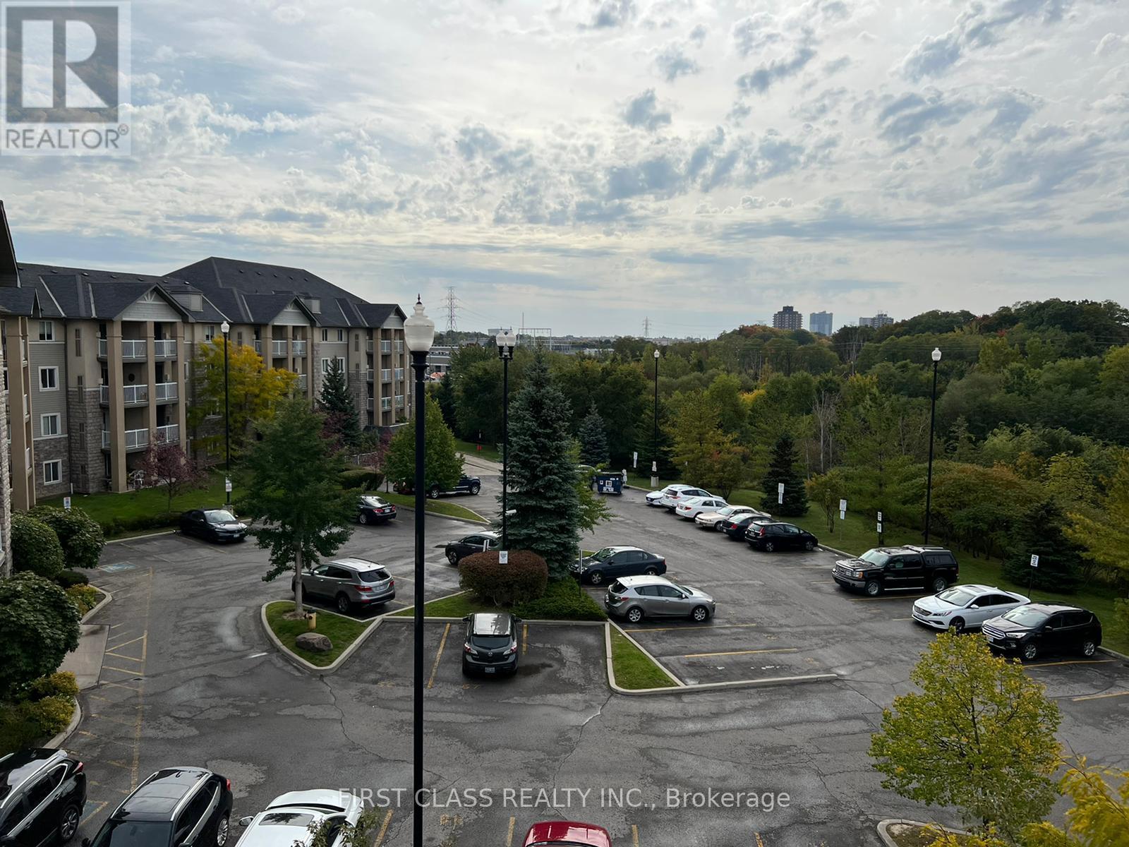 A parking lot with cars and apartment buildings in the background.