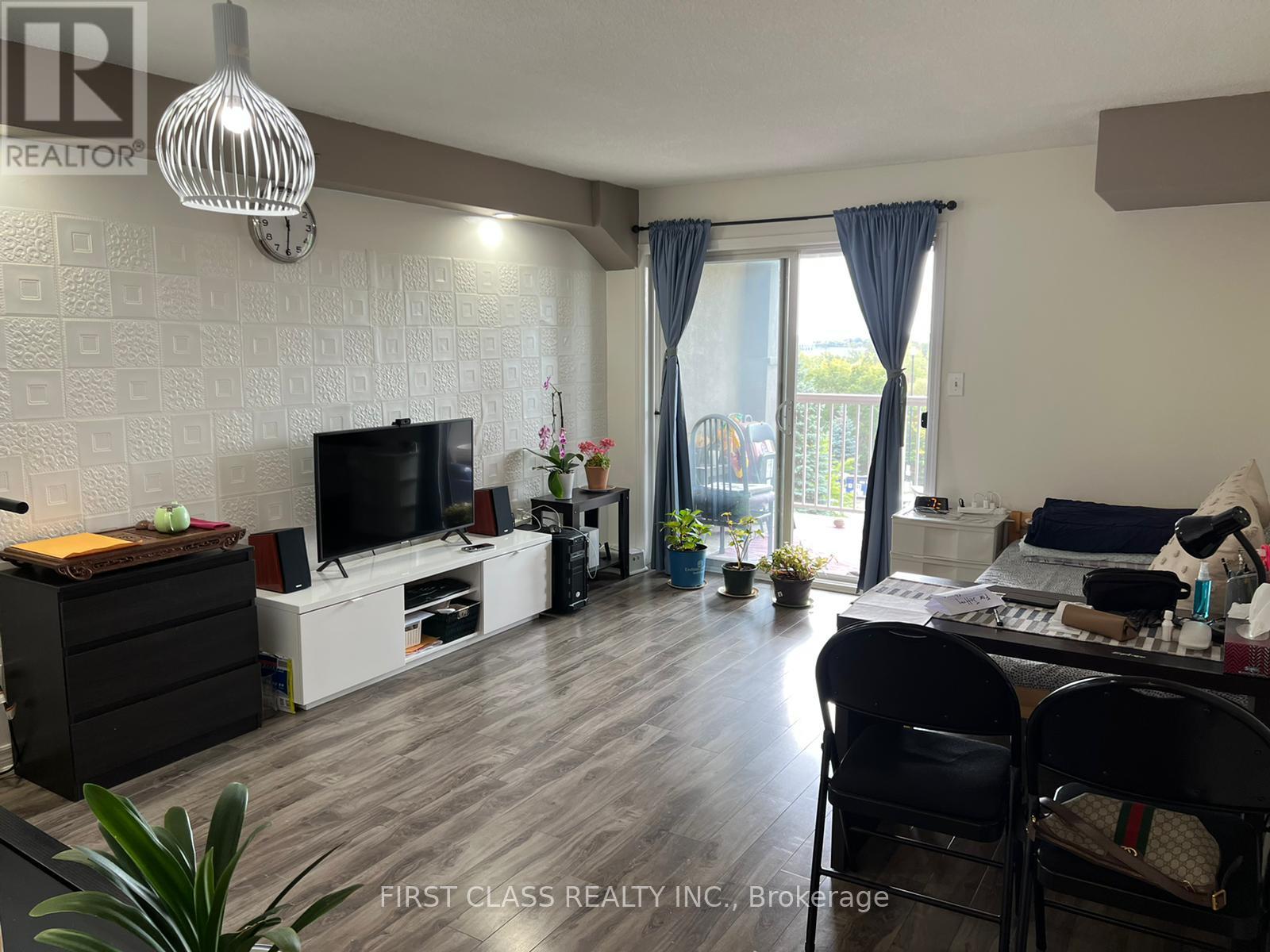A living room with a television, a desk, and a chair.