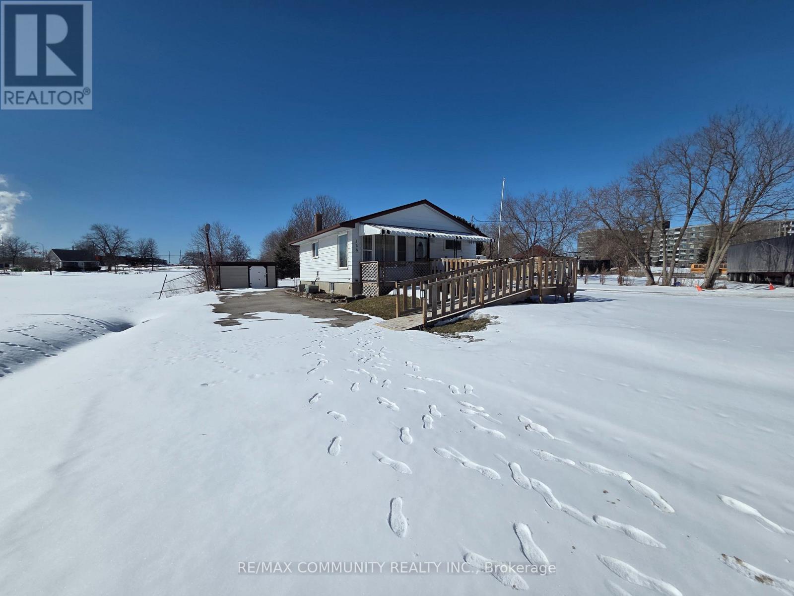 A house with a snow-covered ground in front of it.