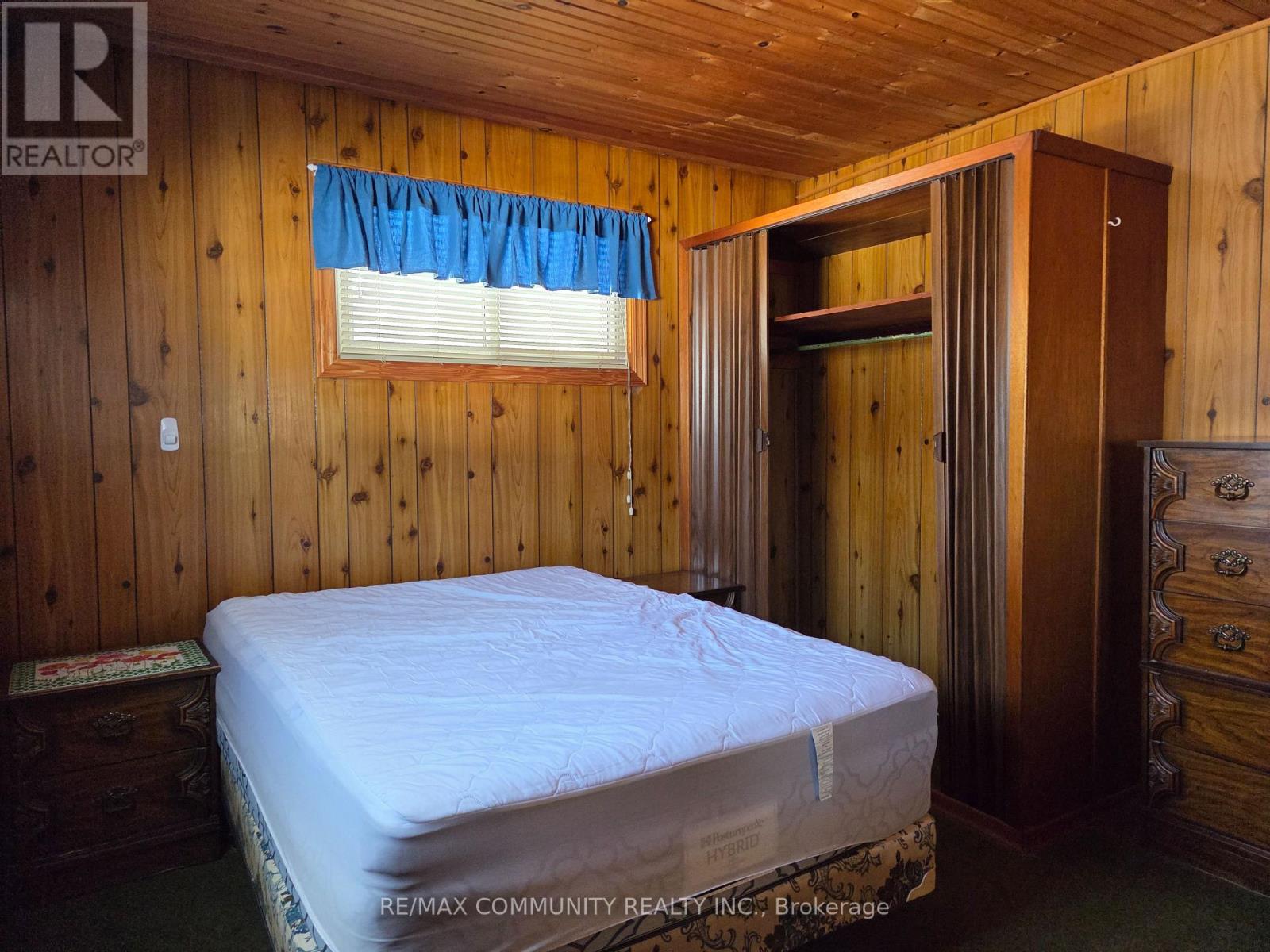 A bedroom with a bed, dresser, and window.