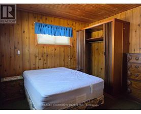 A bedroom with a bed, dresser, and window.