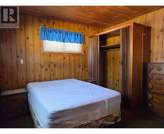 A bedroom with a bed, dresser, and window.