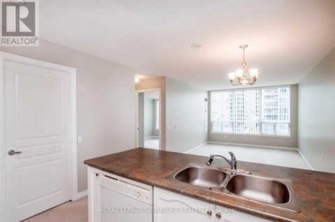 A kitchen with a sink and a chandelier.