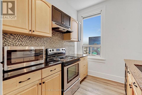 A kitchen with wooden cabinets and a stove top oven.
