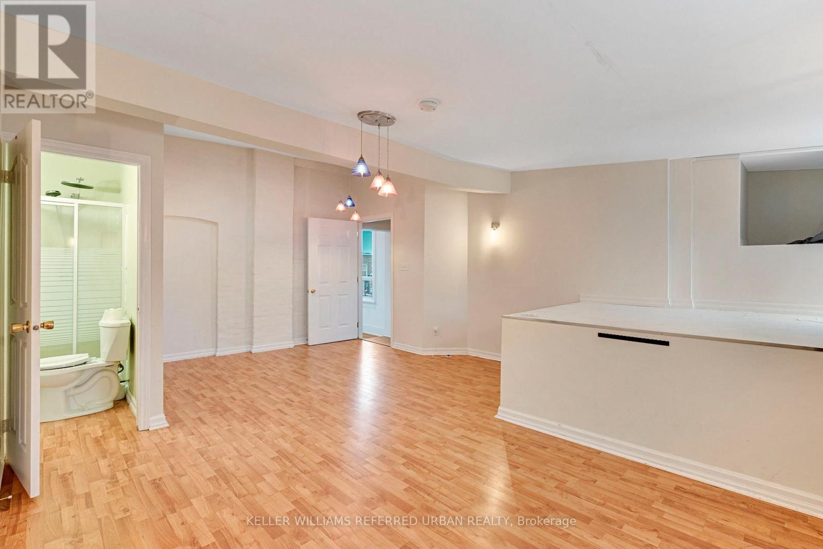 A spacious living room with hardwood floors and white walls.