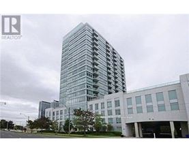 A tall glass building with a modern design is shown in the image.