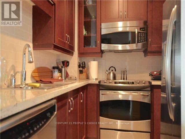 A kitchen with brown cabinets and stainless steel appliances.