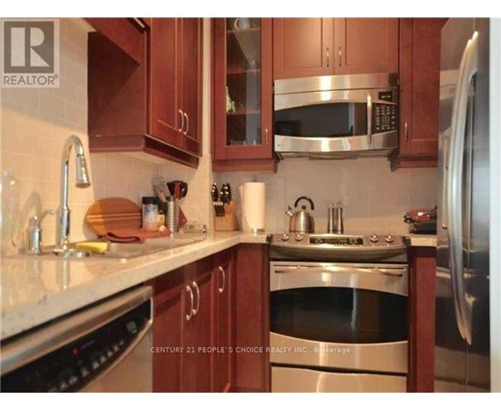 A kitchen with brown cabinets and stainless steel appliances.