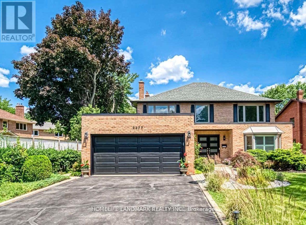 A house with a garage and a driveway in front of it.
