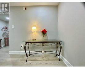 A glass table with a flower and a lamp on it.