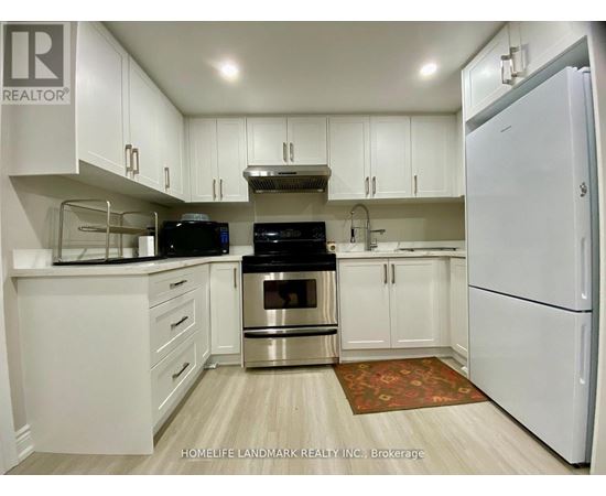 A kitchen with white cabinets and appliances.