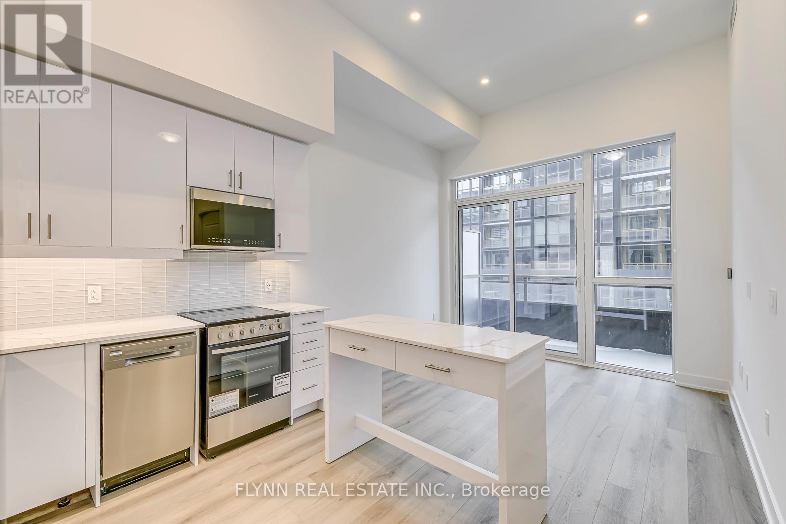 A kitchen with white cabinets and appliances in a real estate listing.
